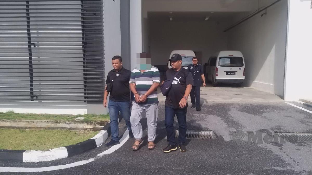 Polis membawa keluar suspek dari Kompleks Mahkamah Kangar yang dikehendaki polis berhubung kes pecah amanah sebanyak RM8 juta membabitkan penjualan tanah. FOTO AIZAT SHARIF
