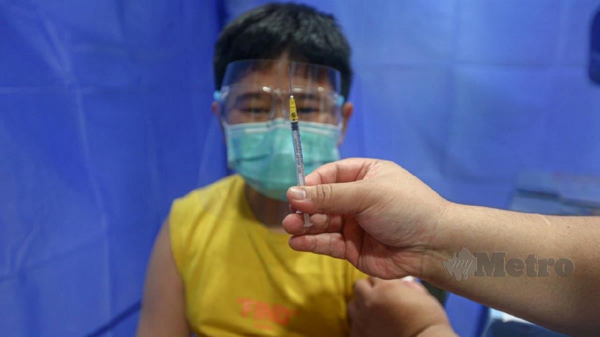CHAN Jun Heng, 11, menerima suntikan vaksin pada Program PICKids di Merlimau. FOTO Syafeeq Ahmad
