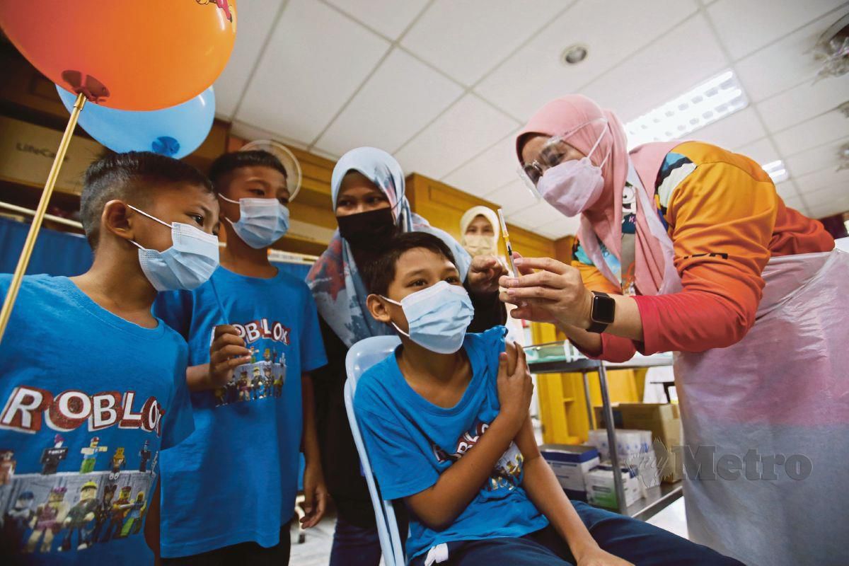 KANAK-KANAK menerima suntikan vaksin Covid-19 di Hospital Teluk Intan, Teluk Intan. FOTO Sharul Hafiz Zam
