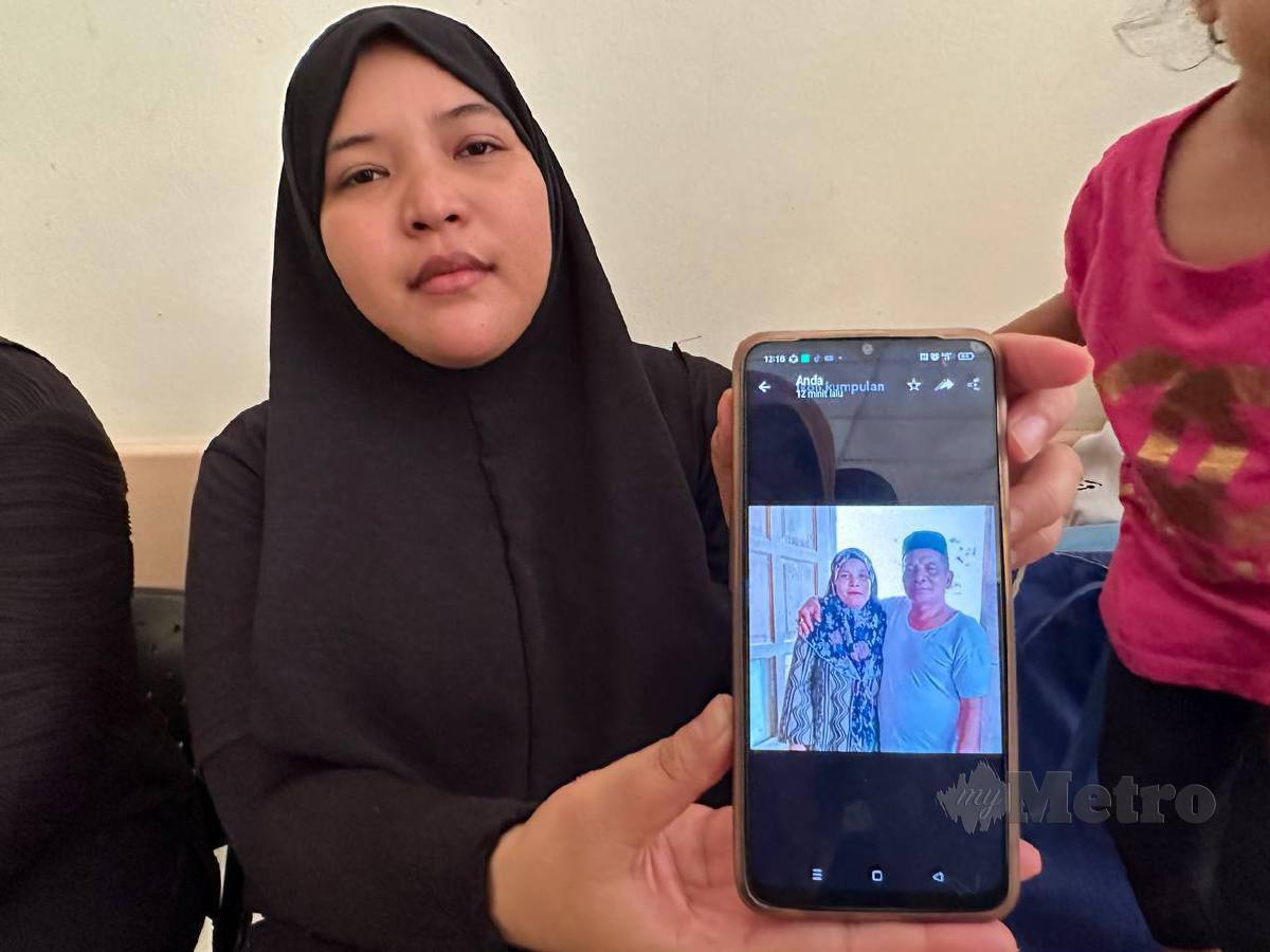 Anak  mangsa, Siti Alora Fatihah Mohd Aziz, 29, menunjukkan gambar arwah ayahnya ketika ditemui di Jabatan Forensik Perubatan Hospital Gua Musang, di sini, hari ini. FOTO Paya Linda Yahya 