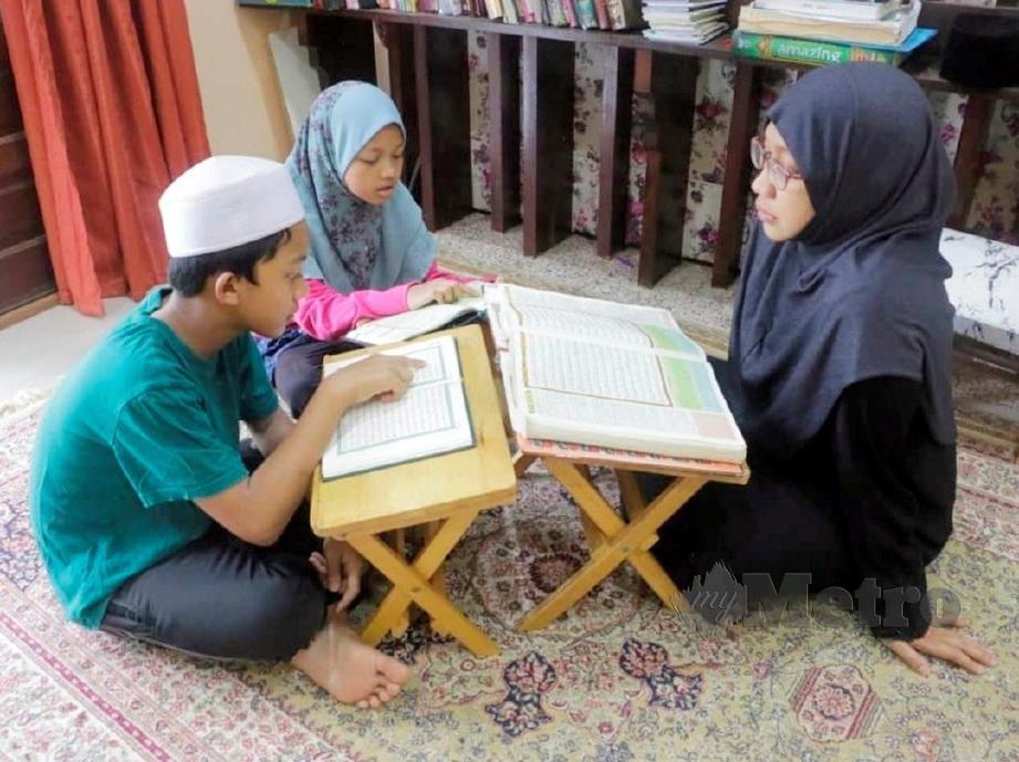 AZREEN (kanan) mengajar dua anaknya, Syed Ahmad Yahya dan Asiah Mardhiyah mengaji.