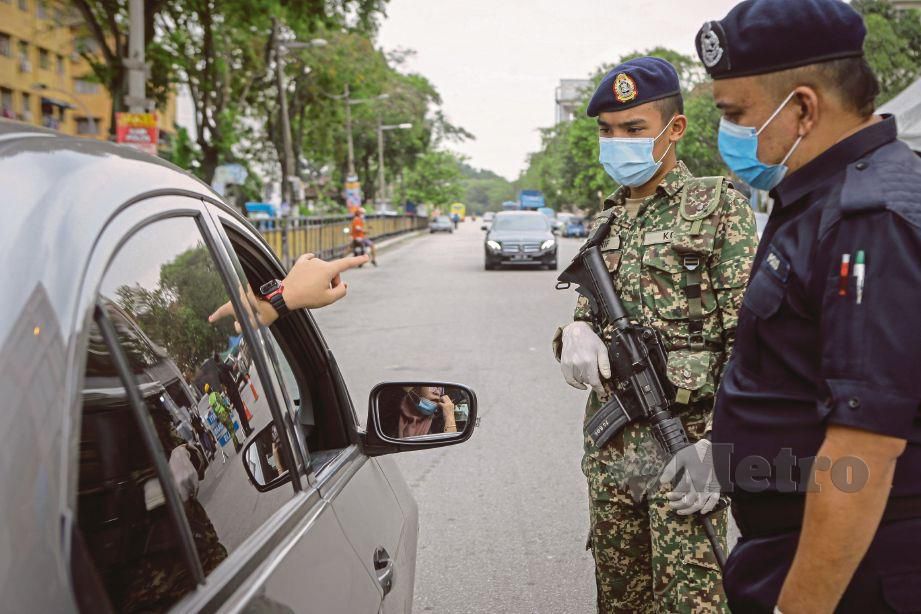 ANGGOTA polis dibantu tentera memeriksa dokumen pergerakan di sekatan jalan raya Jalan Batu Unjur 10, Klang. FOTO arkib NSTP