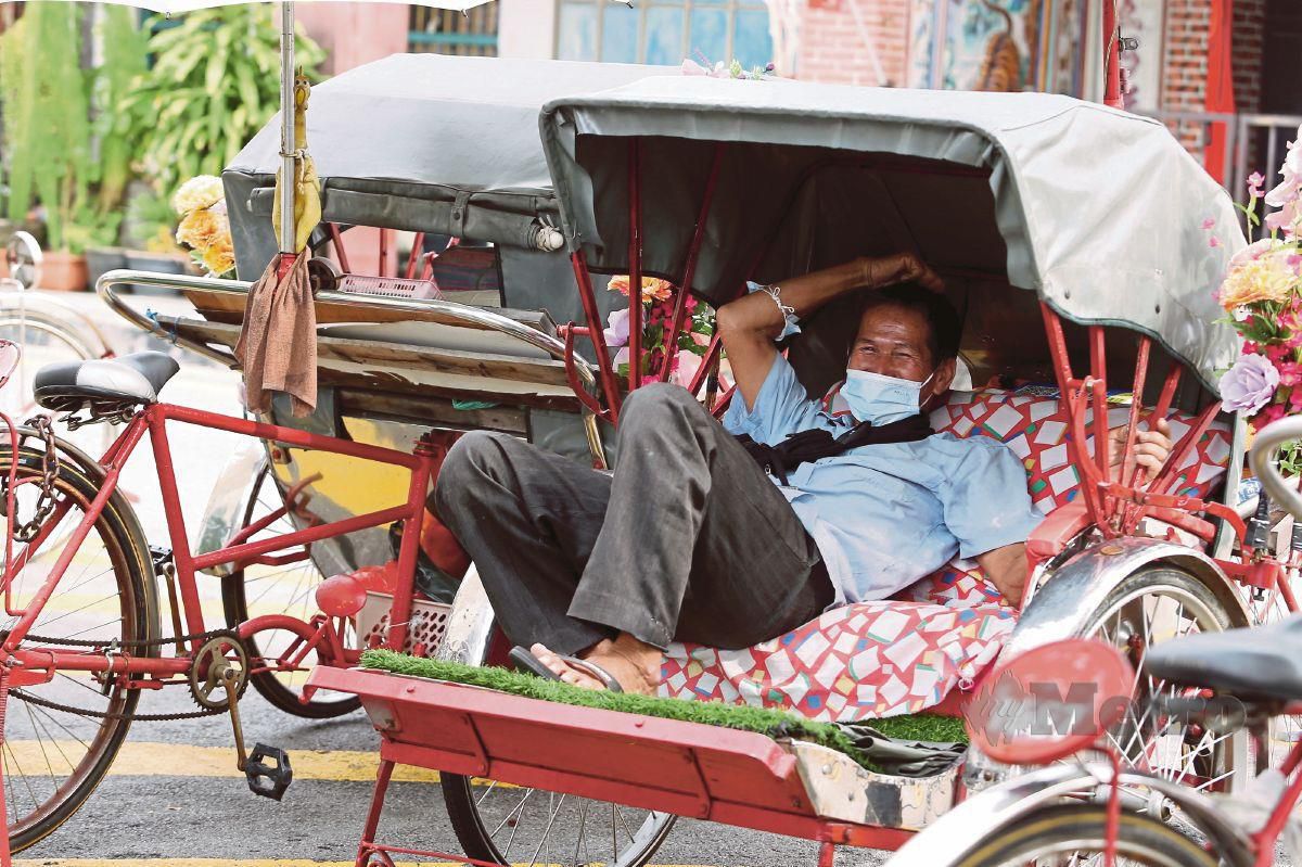 SEORANG pengayuh beca berehat di dalam kenderaannya di Lebuh Armenian, Pulau Pinang.