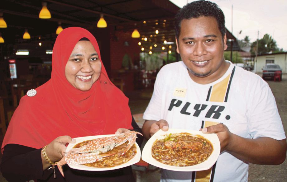 AIZAT dan Haizatul menunjukkan menu popular di restoran mereka.