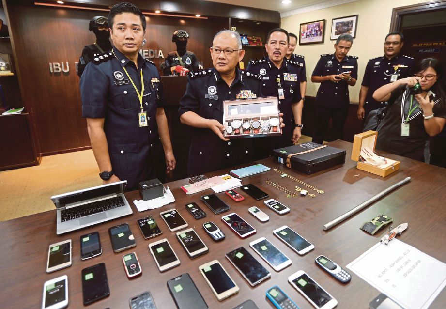 NOOR  Azam  (dua dari kiri)  menunjukkan barang kes yang dirampas daripada kumpulan kongsi gelap Geng 36 pada sidang media di Ibu Pejabat Kontinjen Negeri Sembilan. 