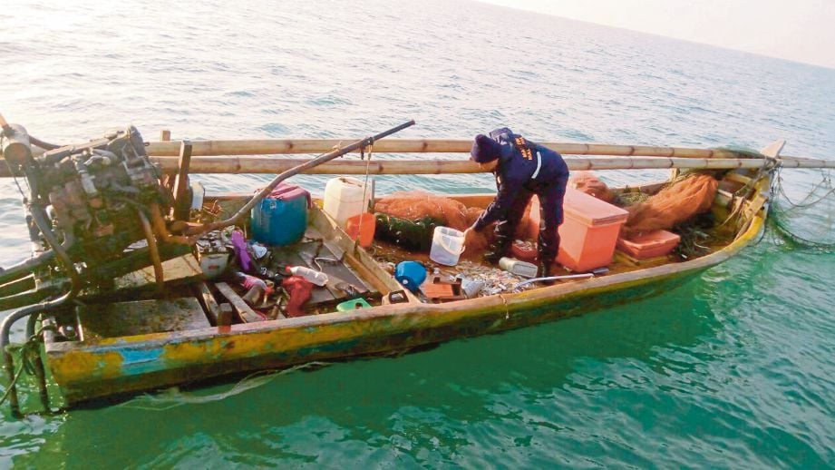 PENGUAT KUASA APMM memeriksa bot nelayan haram yang dirampas.
