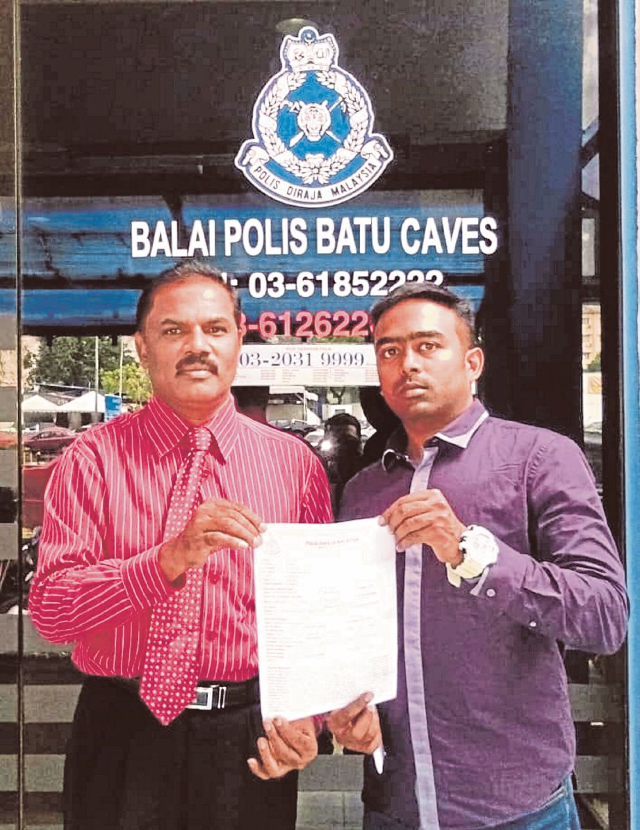 KAMALANATHAN (kiri) bersama Akbarali menunjukkan laporan yang dibuat terhadap majikan di Balai Polis Selayang.