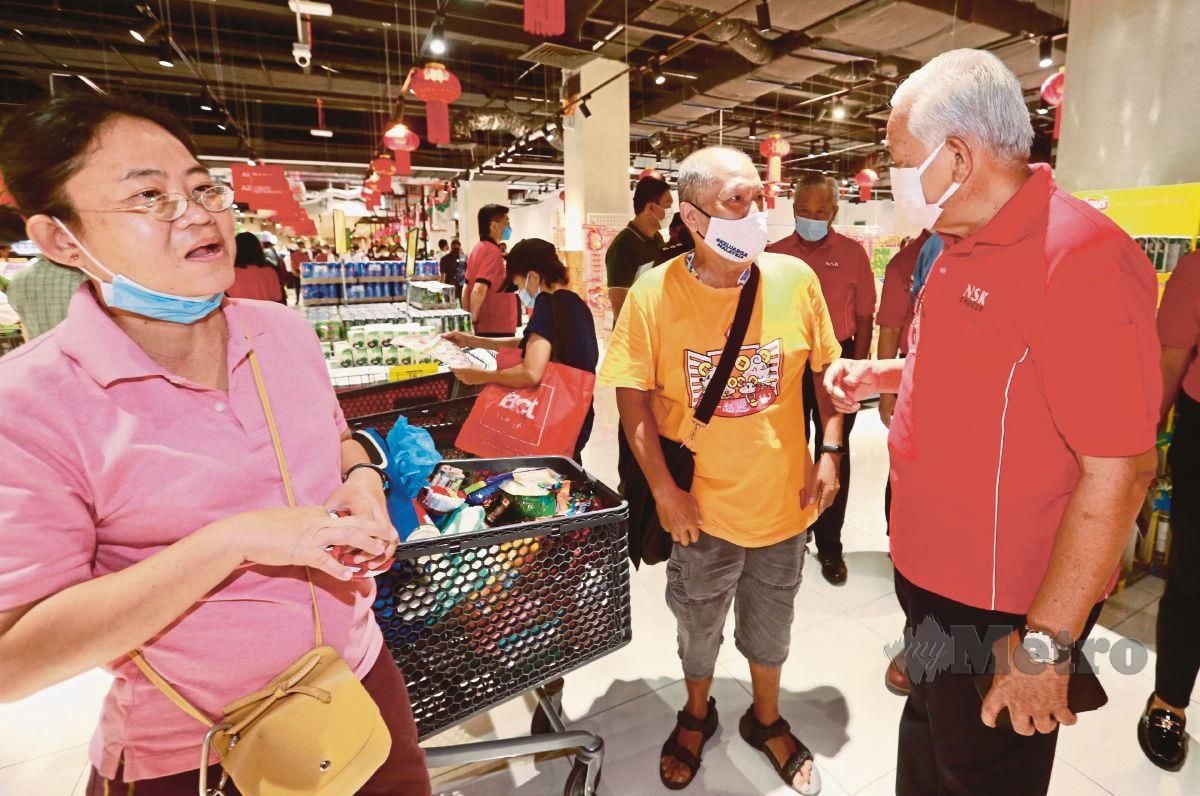 MOHD Shariff (kanan) berbual dengan pelanggan  di  NSK Grocer di Quill Mall.  