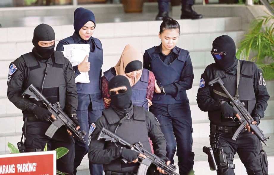 SITI Aisyah (tengah) dikawal ketat oleh anggota polis ketika dibawa keluar dari Mahkamah Tinggi Shah Alam, semalam.