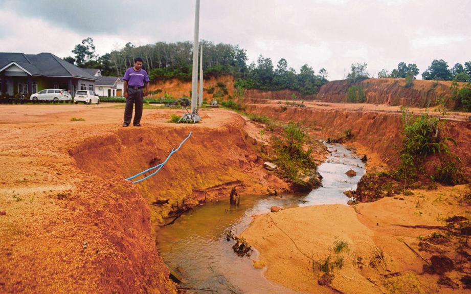 YUSMAROSDI menunjukkan kesan hakisan tanah yang membimbangkan penduduk di Putera Jaya.