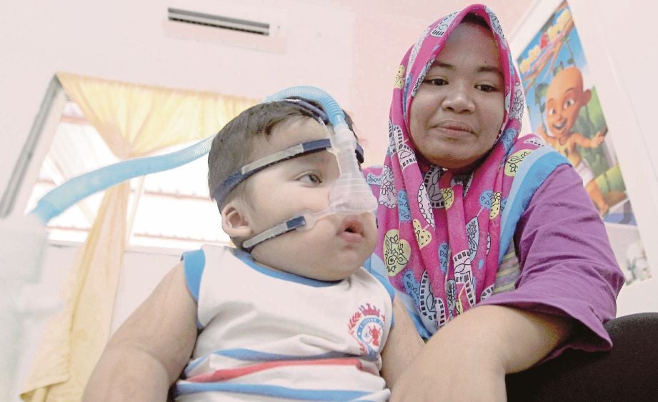IDA Nurul Azwa bersama anaknya, Muhammad Ilham Nazeem  yang menghidap penyakit Sindrom Charge sejak lahir.