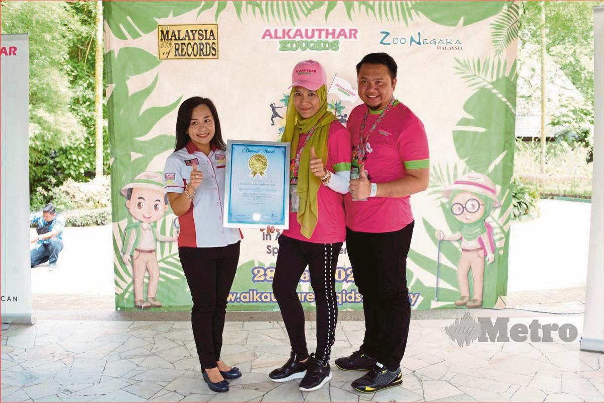 PENGURUS Projek Al Kauthar Eduqids, Datin Dr Nor Fadilah Alias (tengah) diiringi  Dr Bakhtiar Aliff menerima sijil pengiktirafan daripada wakil Malaysia Book of Records selepas berjaya memecahkan rekod bagi perhimpunan sukan kanak-kanak terbesar di negara ini.