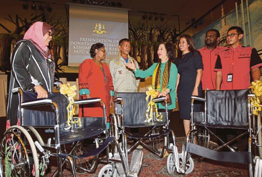 Freida  (empat dari kiri) beramah bersama wakil penerima kerusi roda pada majlis penyerahan sumbangan. 