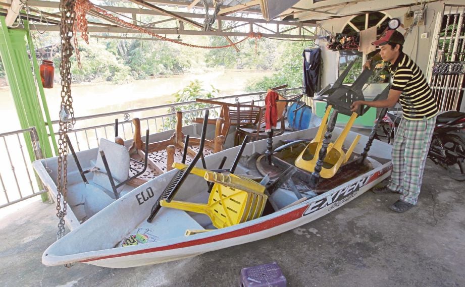  AMIEZE menyusun perabot ke dalam bot di pekarangan rumahnya untuk persiapan menghadapi banjir yang berulang akibat limpahan air sungai berikutan pelepasan air dari empangan Muda di Kampung Lapangan Terbang, Kepala Batas. 