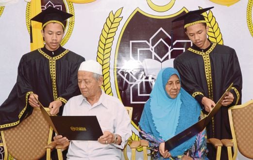 Pasangan  kembar, Nik Ahmad Ridhuan dan Nik Ahmad Radhi menunjukkan diploma kepada  ibu bapa mereka.
