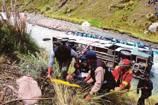 ANGGOTA penyelamat mengusung seorang penumpang yang cedera selepas bas dinaikinya terjunam ke dalam Sungai Mapacho.