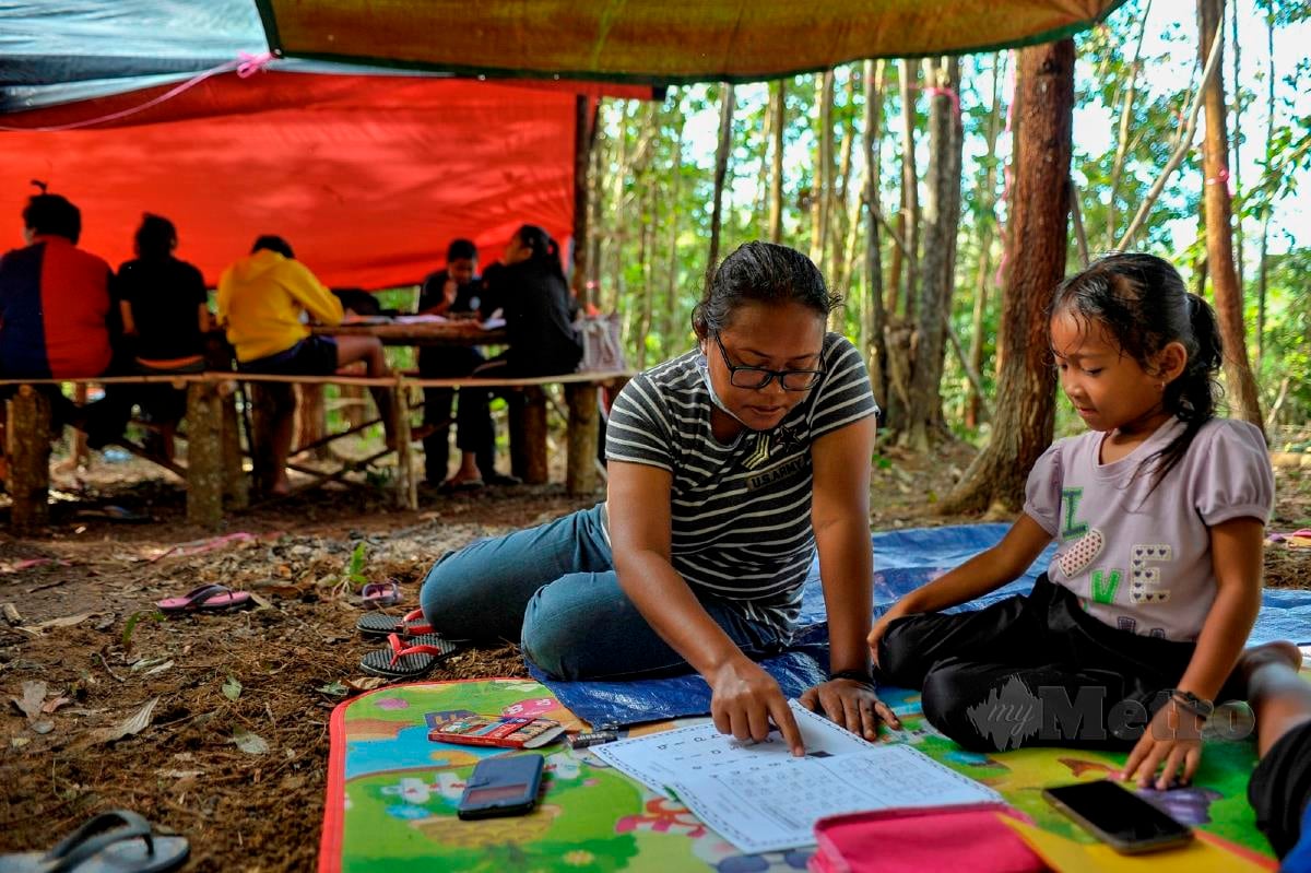 IBU bapa menemani anak masing-masing untuk mengikuti sesi PdPR di bawah khemah di kawasan hutan di Kampung Orang Asli Tamok, Bekok.