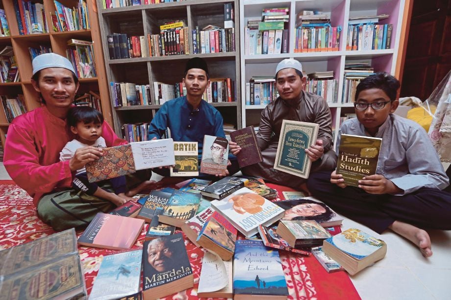 DARI kiri, Mohd Hafidz, 30, Muhammad Fitri, 26, Mohd Saiful Nizam, 38, dan Muhammad Harith, 14 melihat koleksi buku peninggalan arwah ayah mereka Mokhtar Yusof yang merupakan pemilik Dusun Buku di  Kampung Dusun, Kuala Ibai. 