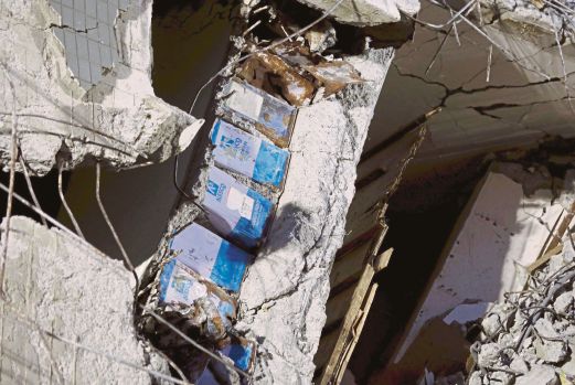 TIN minyak masak dilihat di celah tiang bangunan apartmen yang runtuh di Tainan, selepas gempa bumi Sabtu lalu. 