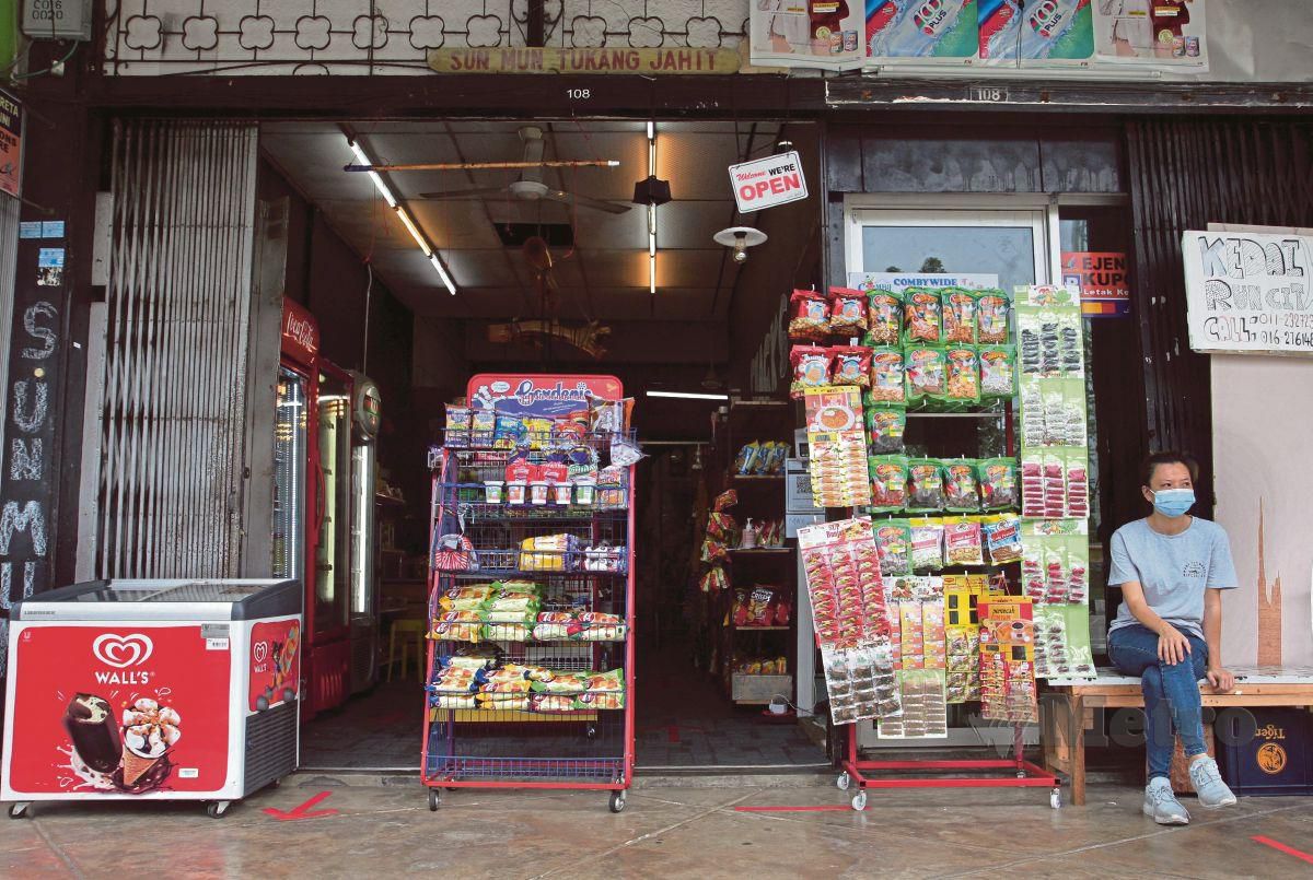 PENIAGA  kedai runcit, Cheong Bee Fong, 37, menunggu pelanggan di premisnya yang lengang di Kuantan.