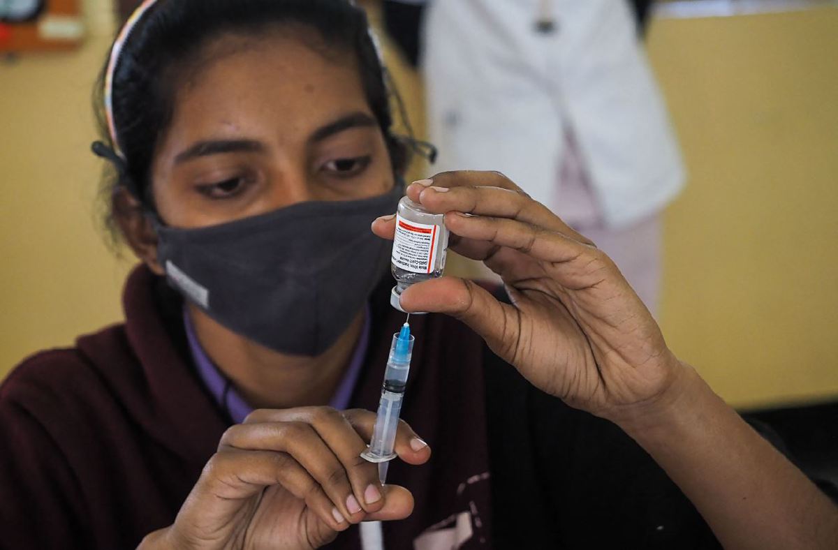PETUGAS kesihatan di India mengeluarkan dos vaksin Covaxin keluaran negara itu untuk vaksinasi penduduk. FOTO AFP.