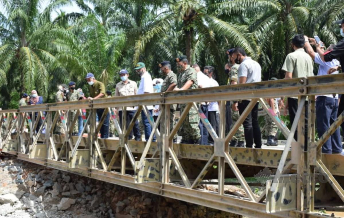 ISMAIL Sabri bersama anggota RAJD melihat Jambatan Compact Bailey 100 di Kampung Sungai Putat. 