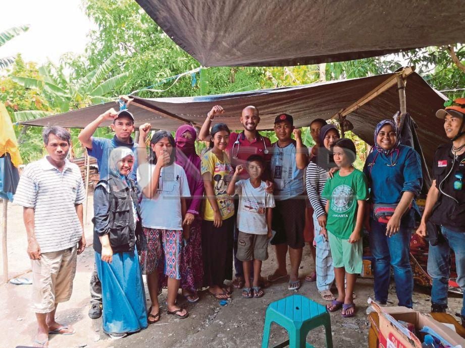 DR Naveenkumar (tengah) bersama penduduk ketika misi bantuan di Palu.