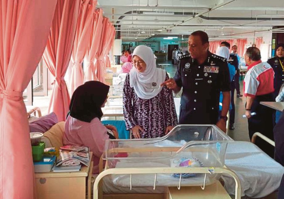 RADZIAH  menyerahkan sumbangan kepada pesakit di Wad Bersalin Hospital Sultanah Aminah (HSA), Johor Bahru, semalam.