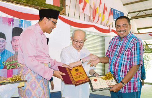 TENGKU Razaleigh (tengah) menyampaikan Anugerah Jasamu Dikenang kepada Ab Aziz.