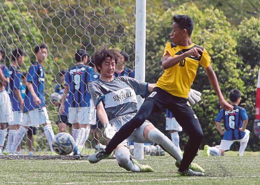 LUQMAN (kanan) menguis bola menewaskan penjaga gol Yokohama.