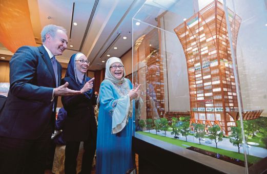   JEAN Gabriel   (kiri)  bersama Tengku Fatihah  (kanan) dan Masila  melihat replika Hotel  Movenpick Kota Bharu pada majlis menandatangani perjanjian,   semalam.