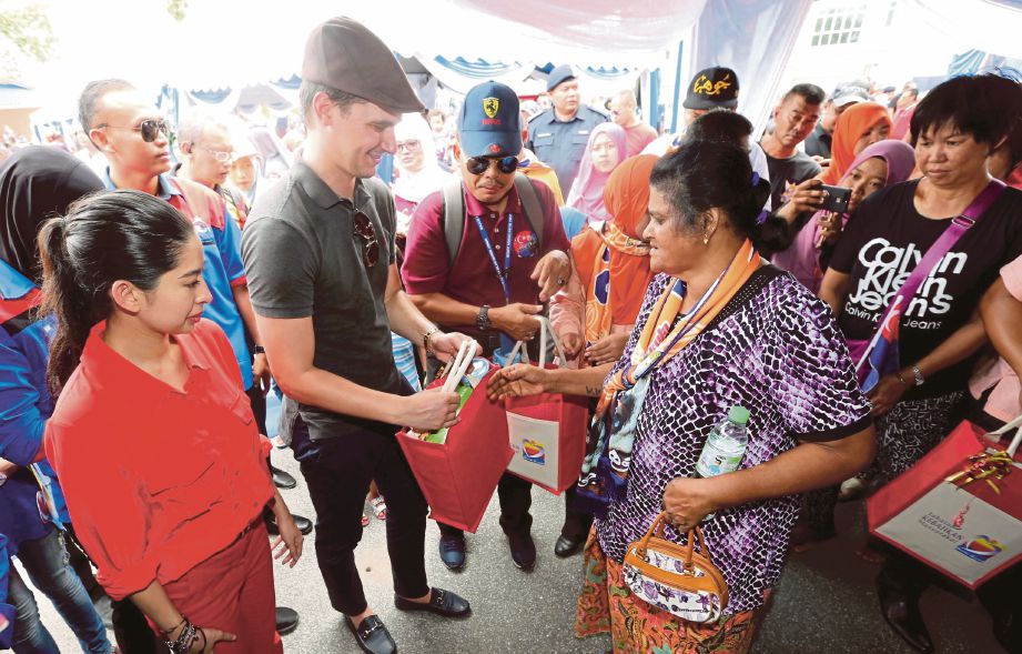  Tunku Tun Aminah  dan suami, Dennis Muhammad  menyampaikan sumbangan kepada  rakyat Johor.