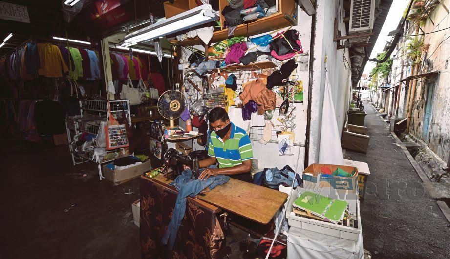 ABDUL Aziz Mohamad Hussain menjahit pakaian pelanggan di Bazaar Penang, Jalan Penang, Georgetown, semalam. 