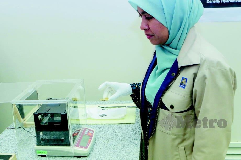 KAKITANGAN NMIM, Noor Razinah Rahmat melakukan eksperimen menggunakan alat pengujian emas. 