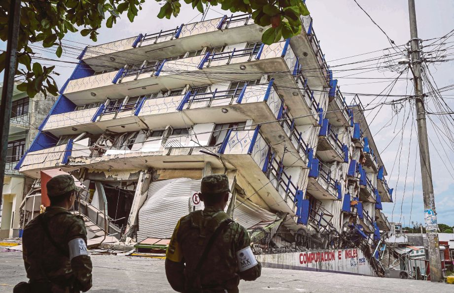DUA askar berkawal berhampiran Hotel Sensacion yang tumbang akibat gempa bumi di Matias Romero, Mexico semalam. - AFP