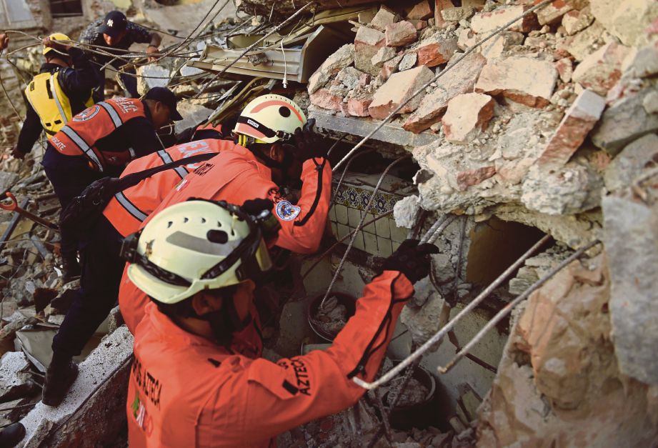 ANGGOTA penyelamat mencari mangsa yang masih terperangkap dalam runtuhan bangunan di  Juchitan de Zaragoza, Mexico semalam. - AFP