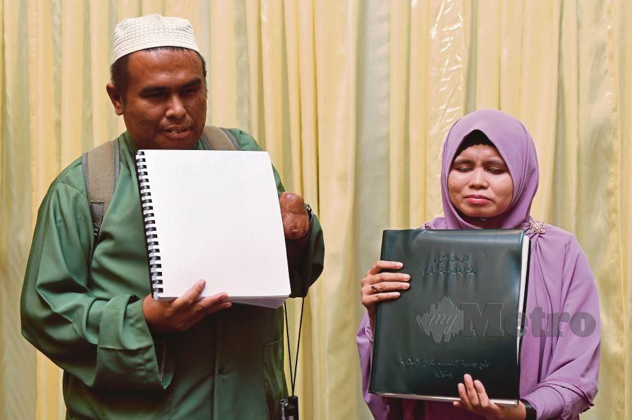 ABDUL Latif dan Afzam memegang al-Quran Braille mereka.