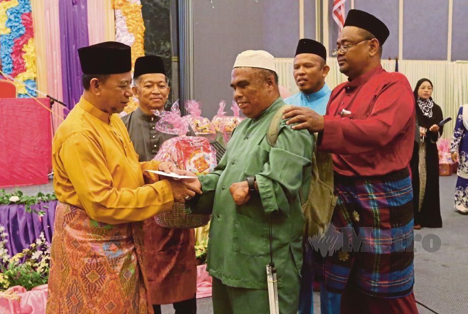 PENGARAH Yayasan Islam Terengganu, Azhar Jusoh (kiri) menyampaikan hadiah kepada Abdul Latif.