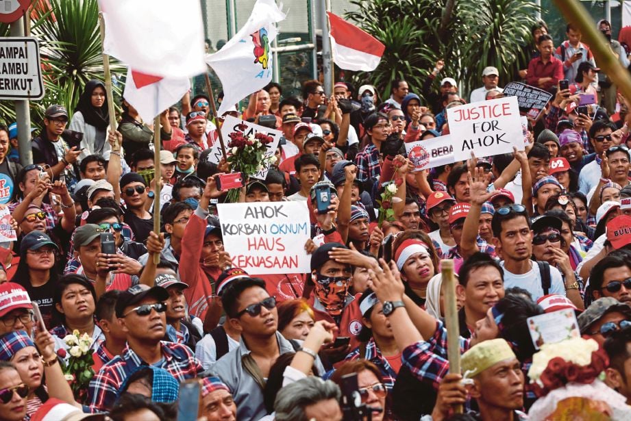 PENYOKONG Ahok mengadakan tunjuk perasaan di luar Penjara Cipinang, tempat Gabenor Jakarta itu dibawa selepas mahkamah menjatuhkan hukuman penjara dua tahun ke atasnya.  - Reuters 