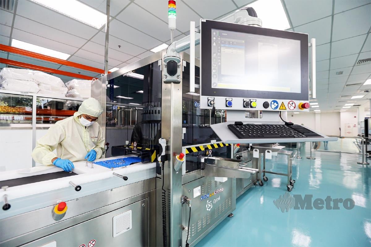 PEKERJA menyiapkan bekalan vaksin di kilang teknologi tinggi Pharmaniaga di Puchong.  