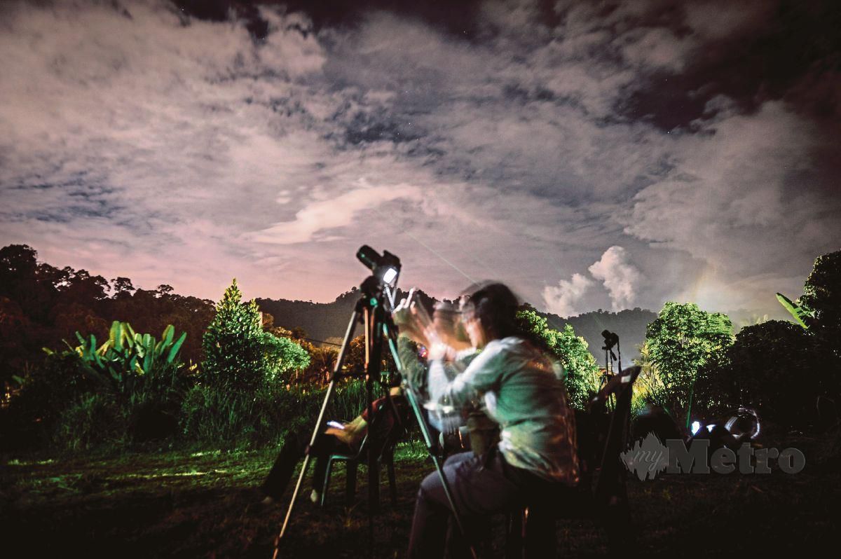 SEORANG jurufoto menunggu untuk merakam gambar hujan meteor Geminid di Balik Pulau pada waktu kemuncak. FOTO Bernama