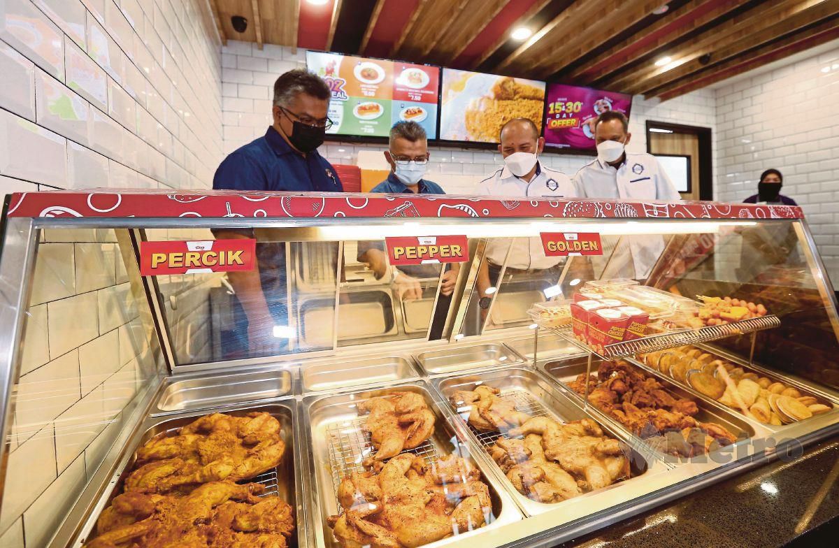 DARI kiri, Mohd Faris, Abd Rahman, Husain dan Yusri melihat pelbagai jenis ayam panggang dijual di Kedai Ayamas di Bandar Dato Onn, Johor Bahru, semalam. FOTO NUR AISYAH MAZALAN