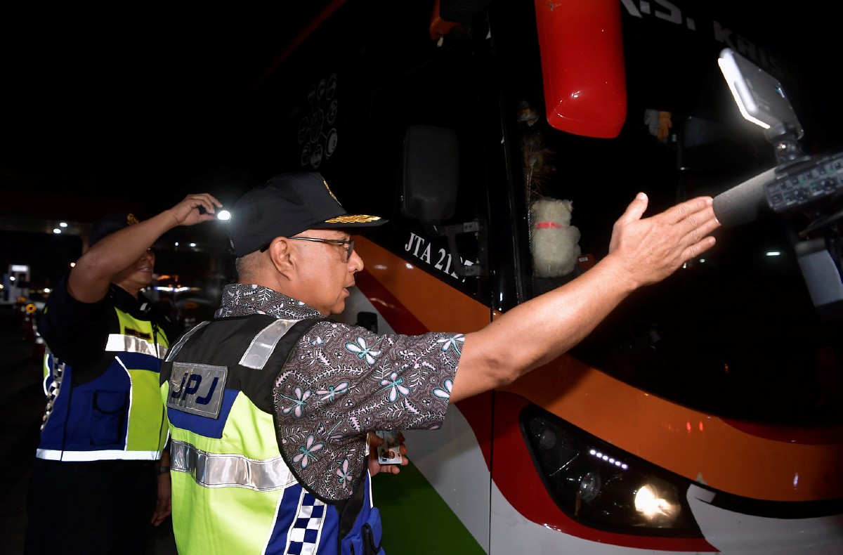 LOKMAN (kanan) menahan seorang pemandu bas persiaran yang tidak memiliki lesen memandu ketika Op Tahun Baharu Cina (TBC) 2024 di Plaza Tol Kemuning arah Kuala Lumpur/Shah Alam hari ini. FOTO Bernama.