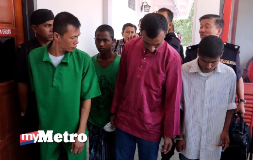 EMPAT orang tertuduh, Biau Wong Chumpo, (kiri) Nurul Islam Nurul Boshor (tiga dari kiri), Momotin Dus Mohamad, (empat dari kiri) dan Shahidullah Syahidullah (dua dari kiri) dibawa keluar dari Mahkamah Tinggi Kangar setelah selesai pertuduhan bagi kes penyeludupan migran di Wang Kelian. FOTO Eizairi Shamsudin