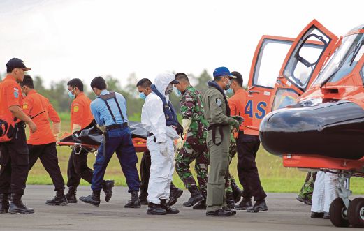ANGGOTA SAR mengeluarkan mayat mangsa dari helikopter di Pangkalan Tentera Udara Iskandar