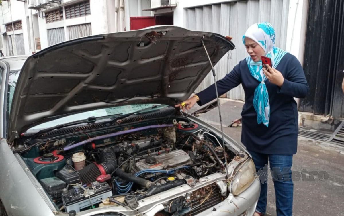  Pemilik Restauran Angah Salai, Isshanira Bahari, 38, menunjukkan injin kereta Satria miliknya yang rosak teruk akibat banjir kilat sejak awal pagi tadi di kawasan Rasah dan sekitarnya. FOTO MOHD KHIDIR ZAKARIA