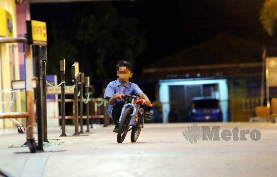 KANAK-KANAK bermain basikal lajak sekitar pasaraya di Manjoi pada waktu malam mengundang bahaya jika berlaku kemalangan. FOTO Muhaizan Yahya