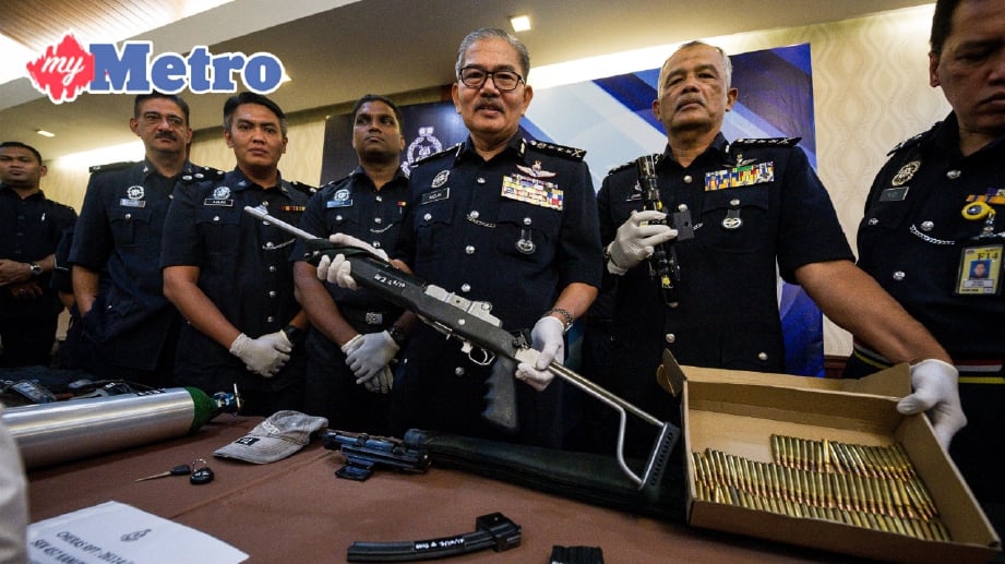 DATUK Mazlan Lazim (tengah) menunjukkan selaras senapang lengkap berpeluru yang dirampas sewaktu sidang media Jabatan Siasatan Jenayah berhubung penangkapan kumpulan pecah rumah Geng 'Ah Leong' di Ibu Pejabat Polis Kontinjen Kuala Lumpur hari ini. FOTO BERNAMA