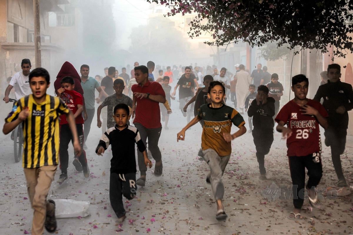 KANAK-KANAK Palestin lari menyelamatkan diri dari serangan udara rejim Zionis yang mengebom kawasan Rafah di selatan Semenanjung Gaza. FOTO AFP