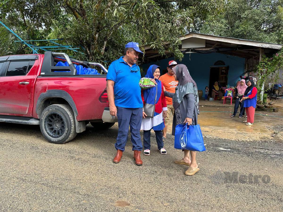 Ab Aziz menyampaikan sumbangan kepada keluarga mangsa terjejas banjir kilat di RKT Jeram Tekoh, di sini, hari ini. FOTO Paya Linda Yahya
